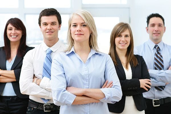 Team of business employees looking forward with arms crossed